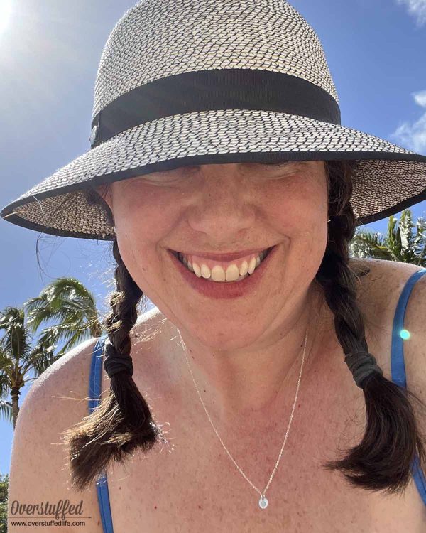 woman wearing hat and made by mary necklace in the sunshine